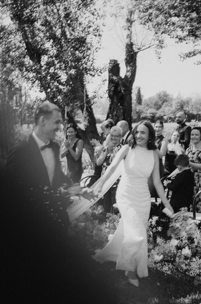 Joyful wedding exit with bride and groom at La Finestra Sul Fiume captured on film