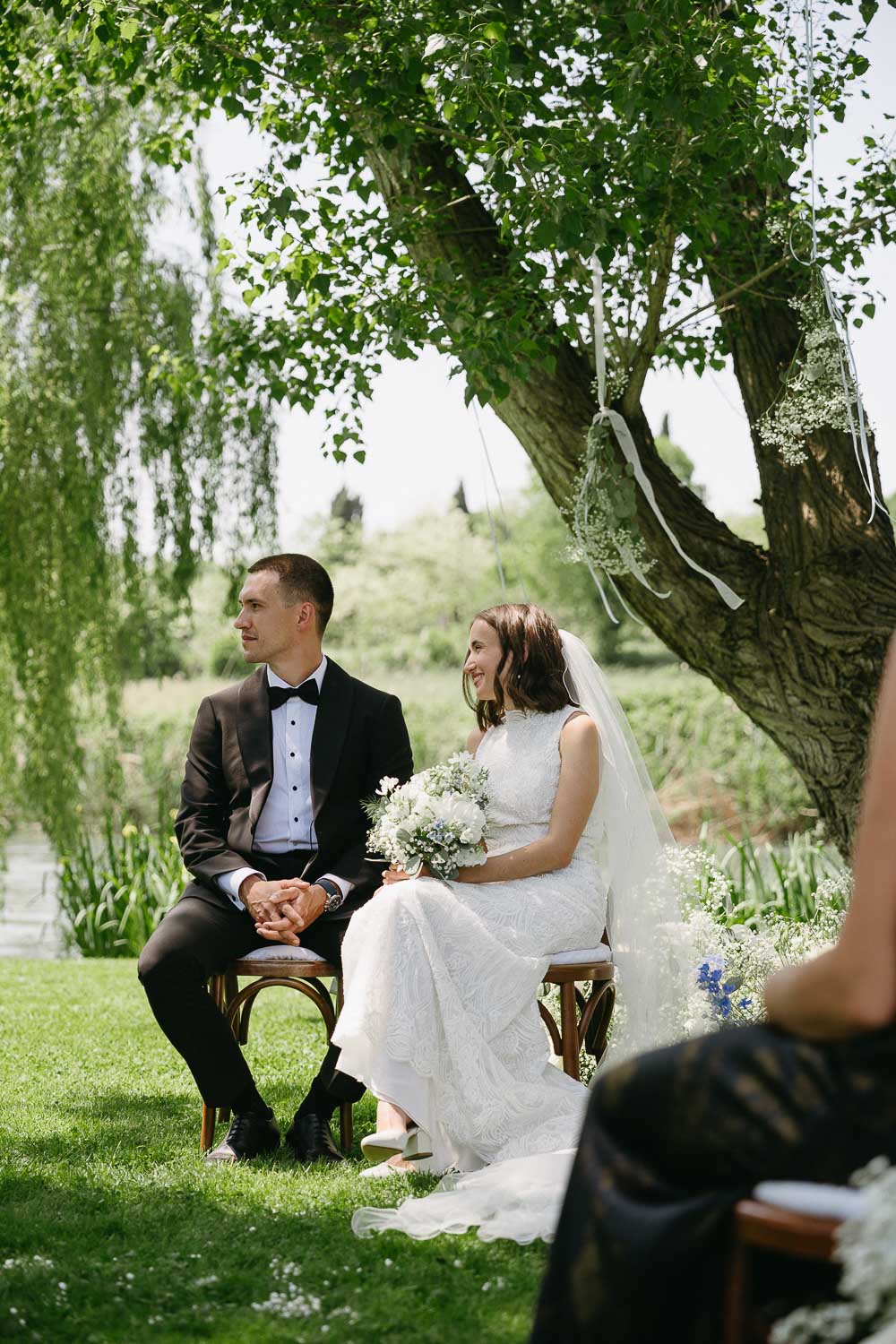 Bride and groom seated together during Italian countryside wedding ceremony