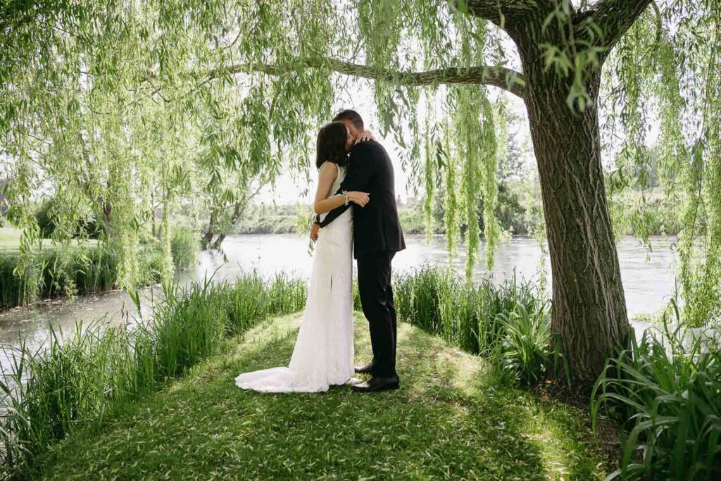 Couple sharing intimate moment beneath hanging greenery