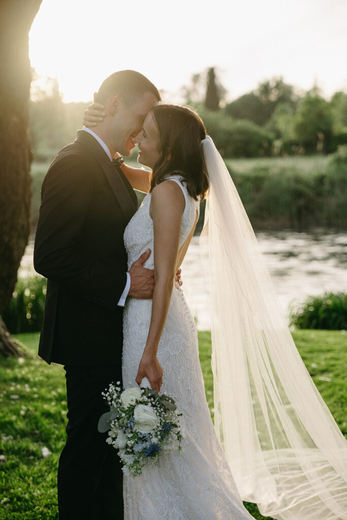 Golden hour wedding photo with flowing veil and soft light