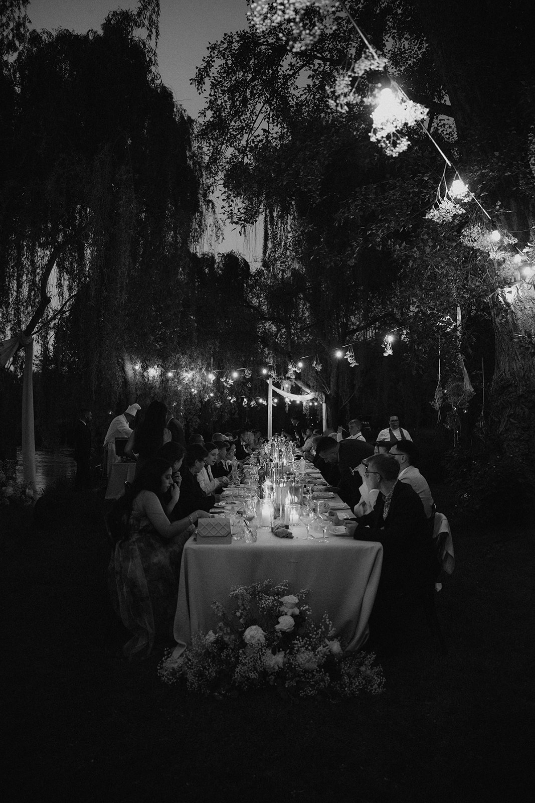 Candlelit reception under string lights at La Finestra Sul Fiume with guests dining