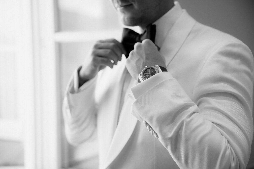 Bräutigam im weißen Smoking bereitet sich auf Hochzeit am Tegernsee vor