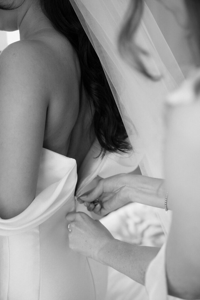 Braut wird beim Ankleiden am Tegernsee für ihre Hochzeit vorbereitet