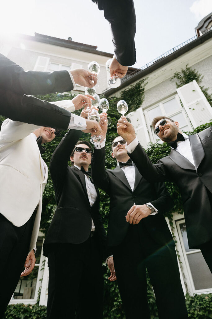 Grooms Men stoßen stilvoll vor Hochzeitslocation am Tegernsee an