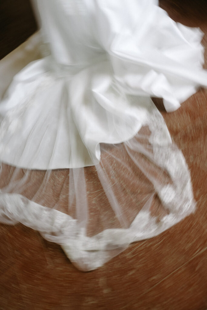 Ein verwischtes Bild eines Details von einem Brautkleider und dem Schleier